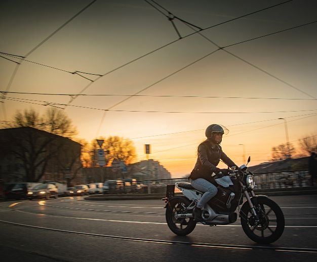Super soco TC Max being ridden through a europen city at sun set