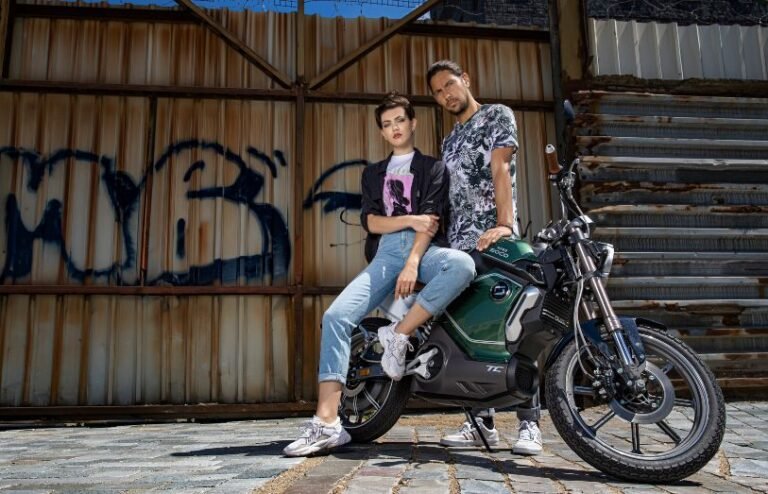 young fashionable couple on a super soco TC electric motorcycle