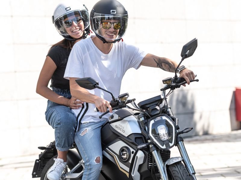 young couple on a TSX super Soco electric Motorcycle