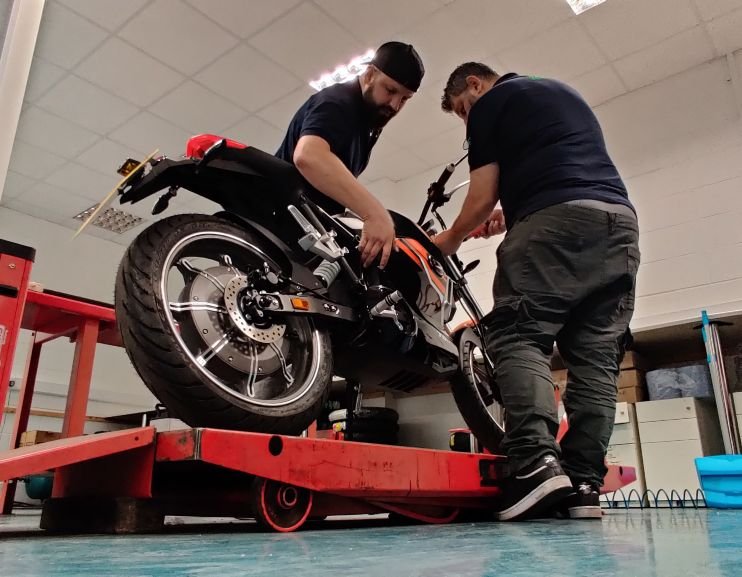 two mechanics working on an electric motorcycle