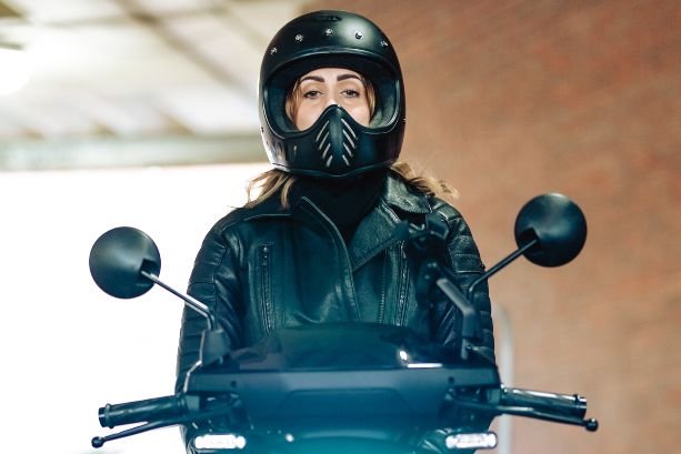 young girl sart on an electric moped wearing black gear